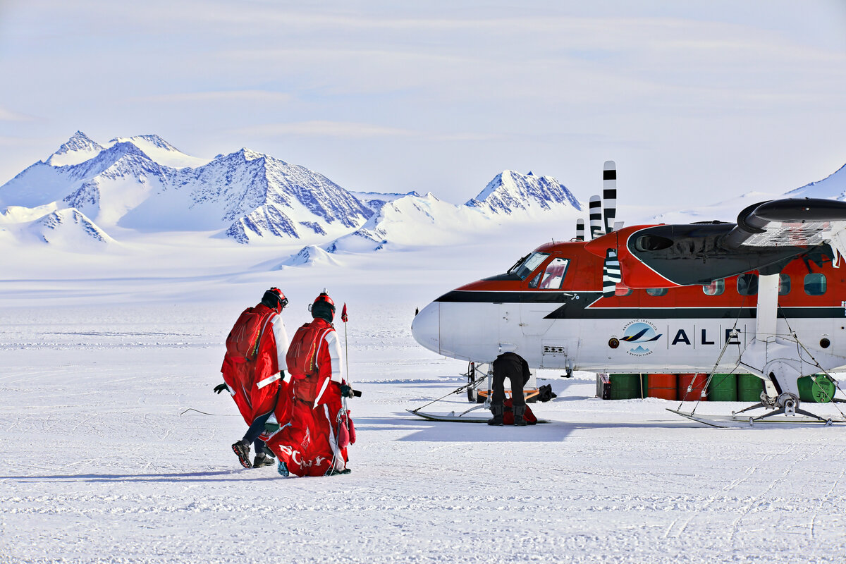 Wingsuiters walk towards the Twin Otter