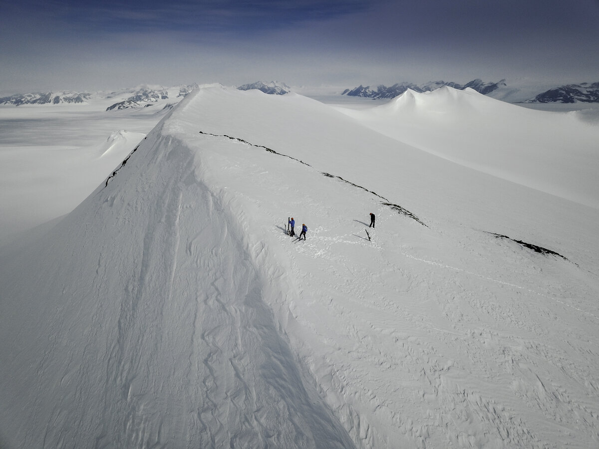Skiers hike up the slope above Three Glaciers